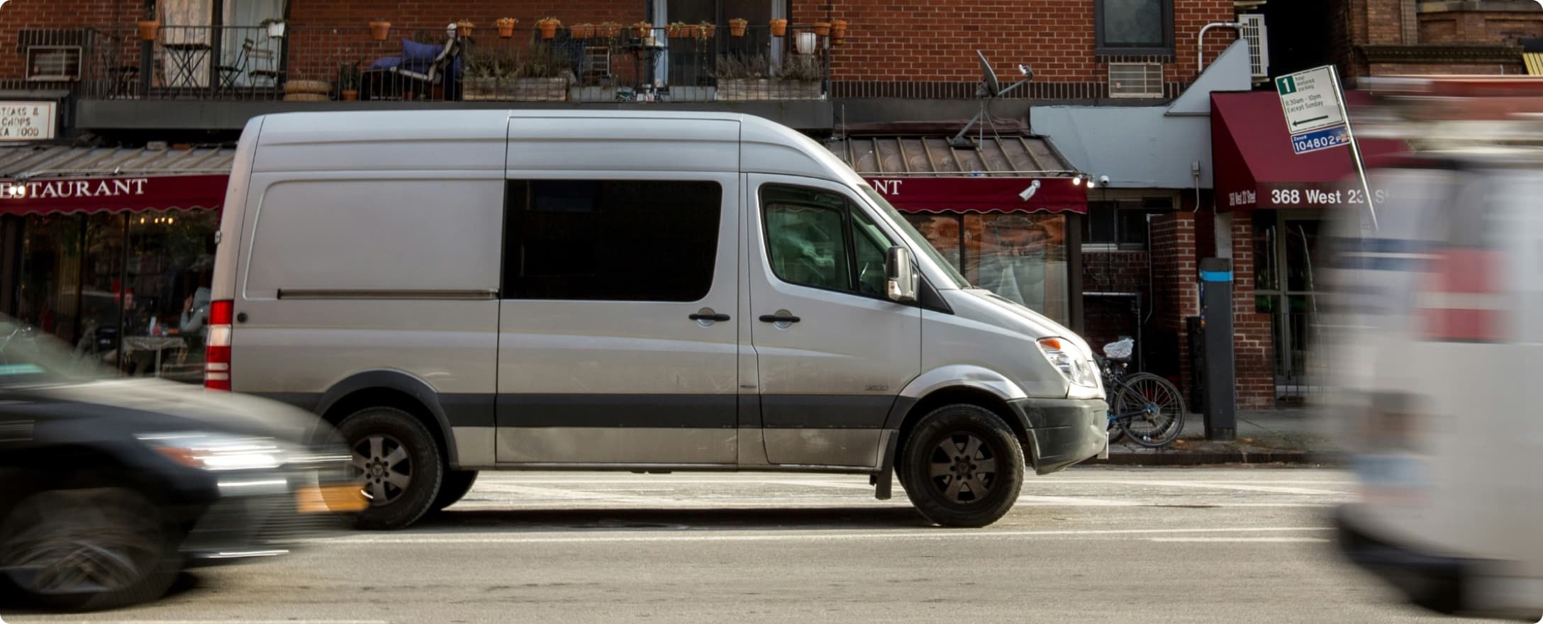 Curri nationwide delivery fleet Sprinter van completing a last-mile construction and building materials delivery through a busy city street