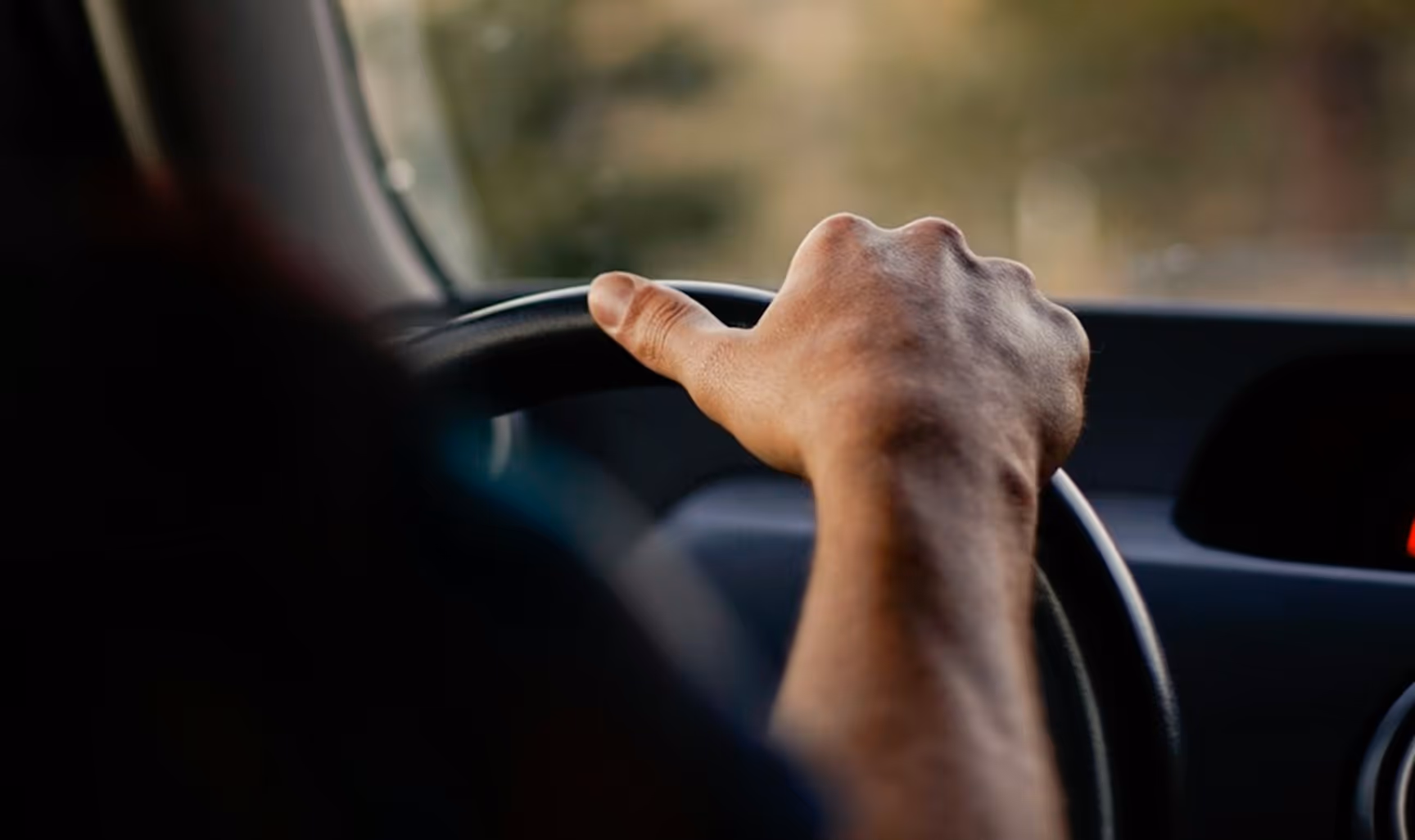 Cargo van driver works his clipboard at the wheel on a vehicle-transport final-mile run, handling the keys, paperwork, and accessory drops that back up dealership, auction, and wholesaler transfers.