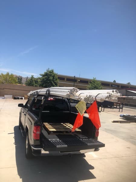 Flatbed truck at a job site being unloaded for a Curri delivery